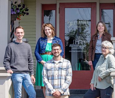 5 people stand on the porch of the Downtown Everett Association building in Everett, Washington.