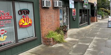 Sidewalk scene with storefronts and signs showing 'Open' and 'Over 30 years'.