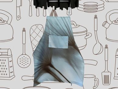 Apron with abstract design hanging in a kitchen setting.