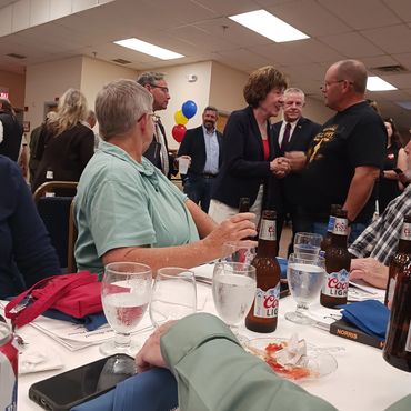 People socializing at a formal event with drinks.