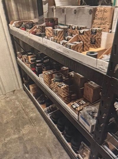 Shelves filled with organized boxes and parts in a storage room.