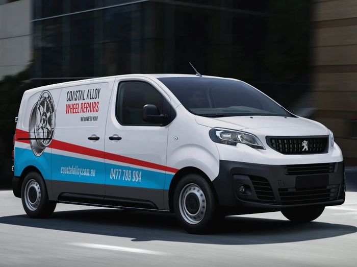 Coastal Alloy Wheel Repairs branding driving on a city street.