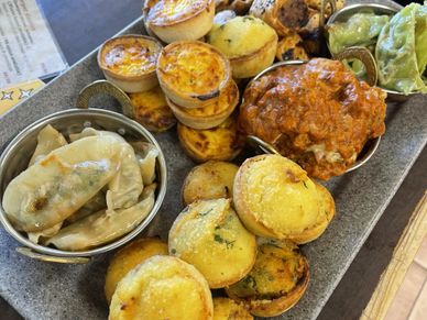 A platter of assorted savory pastries and steamed dumplings.