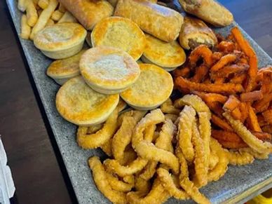 A variety of fried snacks and pies on a platter.