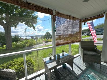 Peaceful porch with chairs and an American flag.