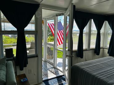 Room with American flag seen through open door.