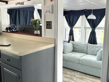 Cozy living room with gray couch and dark curtains.