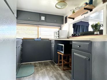 Compact kitchen area with gray cabinets and appliances.