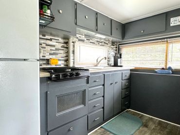 Modern kitchen with gray cabinets and tiled backsplash.
