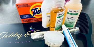 A box of tide detergent, soap, toothpaste, and shampoo.