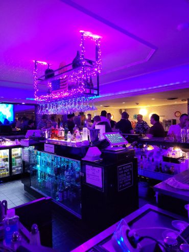 Bar scene with purple lighting and patrons.