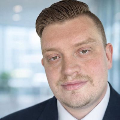 Professional man in a suit with a slight smile.