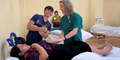 Healthcare professional attending to a patient on a bed.