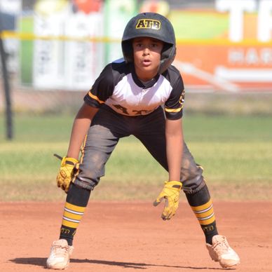 Young baseball player in ready stance on the field.
