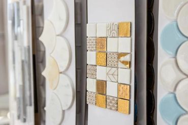 Display of various decorative tile samples in different shapes and textures.