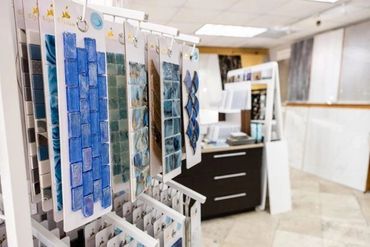 Display of blue tile samples hanging in a showroom.