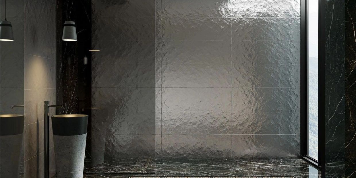 Modern bathroom with a sleek black and gray design and a tall pedestal sink.