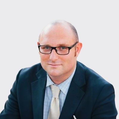 Professional man in suit and glasses against plain background.