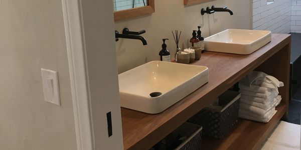 Custom open floating vanity with mirror frames to match.