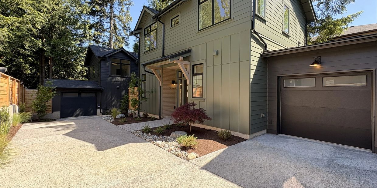 Modern two-story house with clean driveway and garage spaces.
