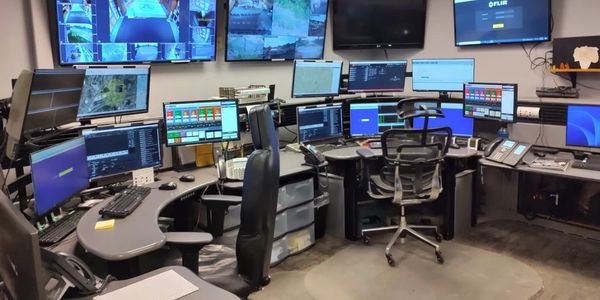 A control room with multiple monitors and office chairs.