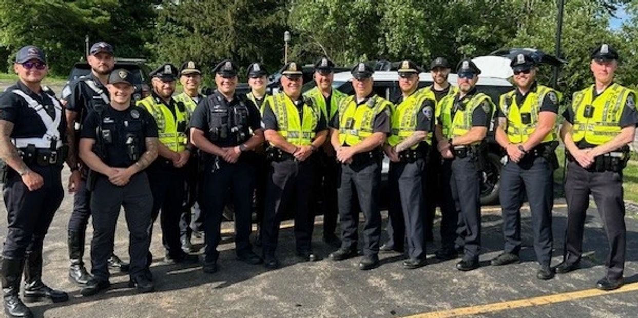 A group of police officers standing together outdoors in uniform.