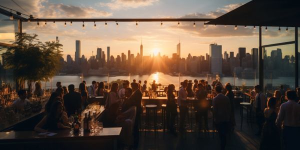 People enjoying sunset at a rooftop bar with city skyline view.