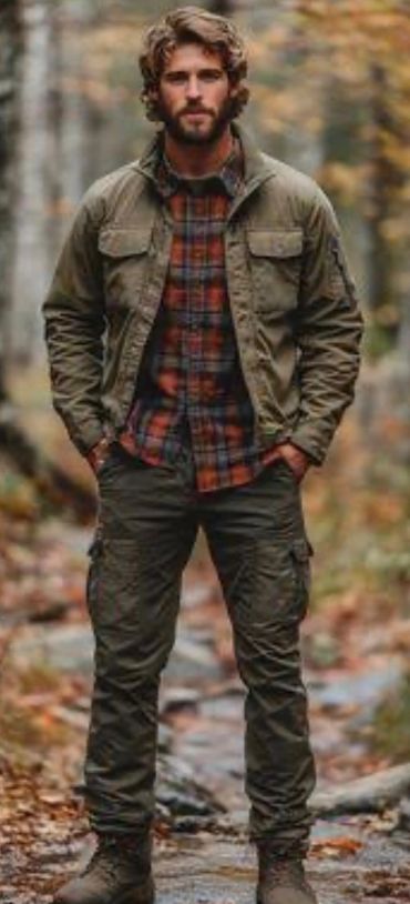 Man in outdoor gear standing on a forest trail in autumn.