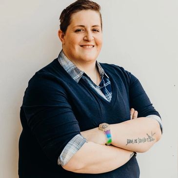 Confident person smiling with arms crossed.