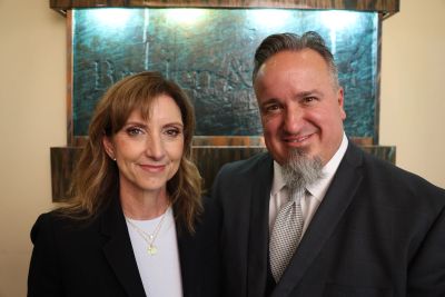 Smiling man and woman in formal attire posing indoors.