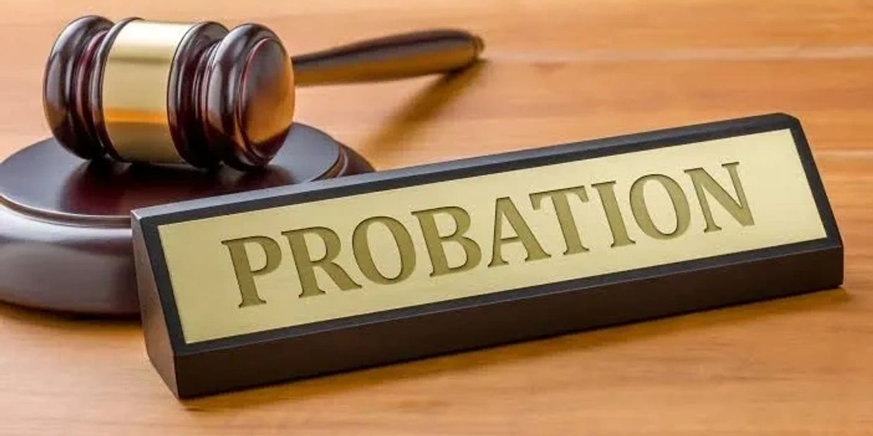 Wooden gavel and probation nameplate on a desk.