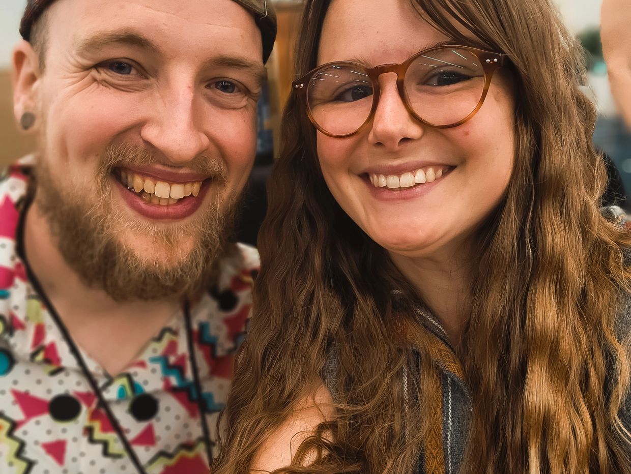Happy young couple smiling together in a close-up selfie.
