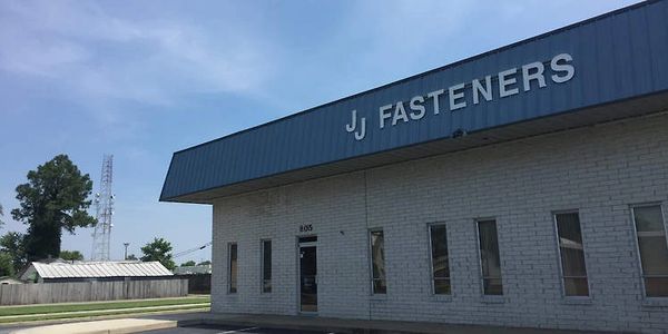 Exterior view of JJ Fasteners building under a clear sky.