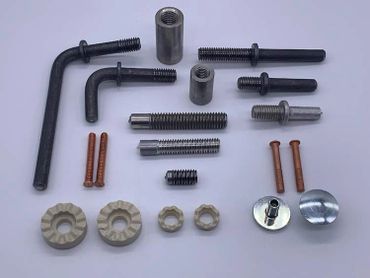 Assorted metal screws, bolts, and washers organized on a white surface.