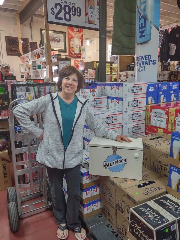 The winner of a giveaway, leaning on the cooler, proud that she's won.