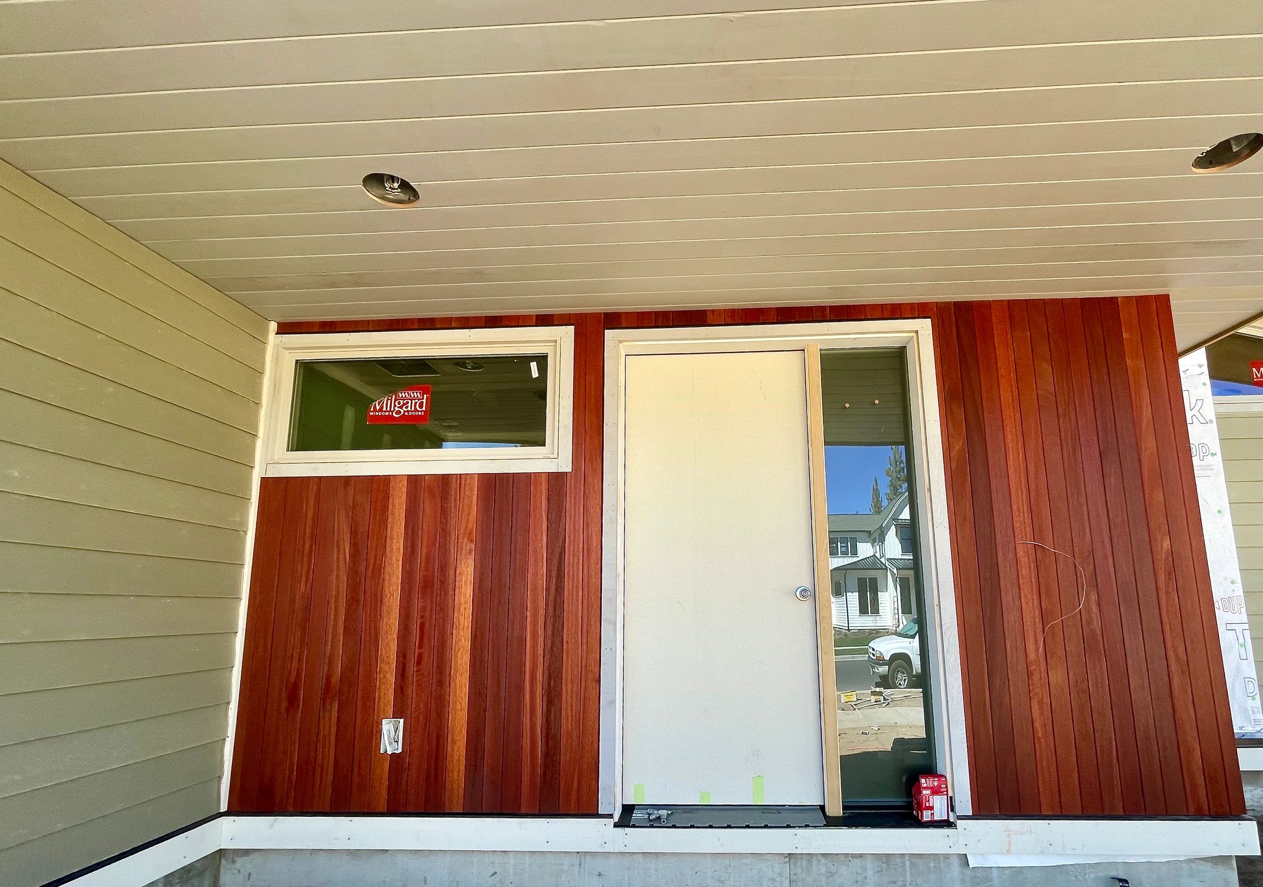 Close up of new cedar siding and a freshly installed entry door on a Bend, Oregon home by Elite Construction Contracting