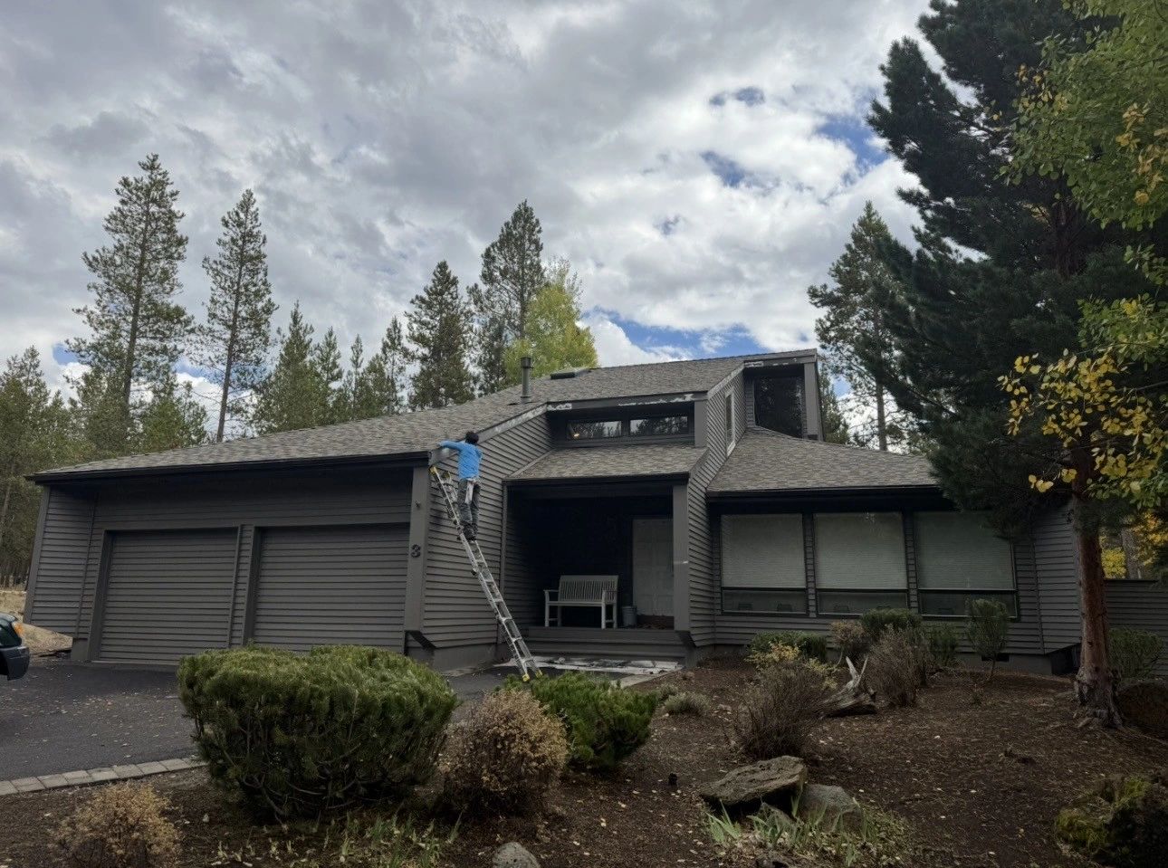 Siding repair and repaint underway on a two story home under the pines, typical of Elite Construction Contracting work in Sunriver, Oregon