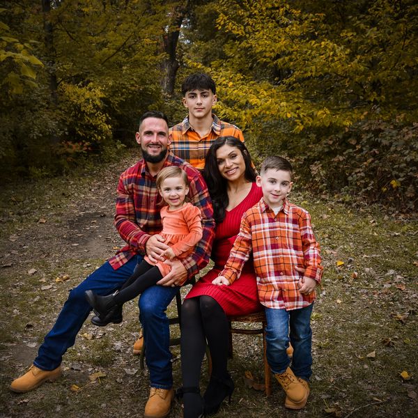 Family in autumn setting with plaid shirts and warm colors.