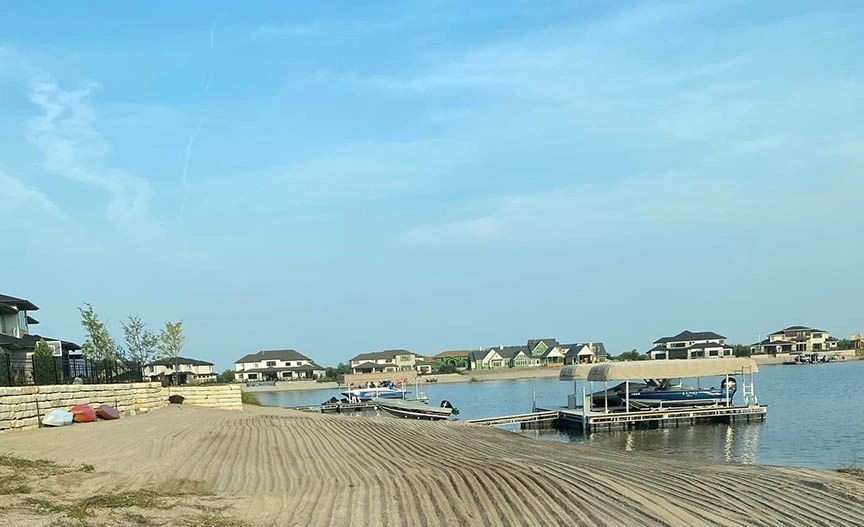 Houses, docks, boats near a freshly graded beach.