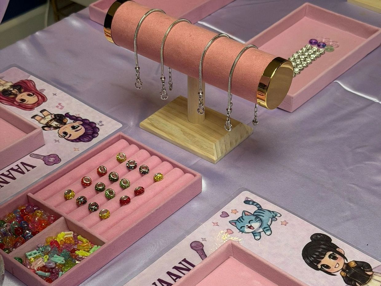 Jewelry display with bracelets and beads on a purple table.