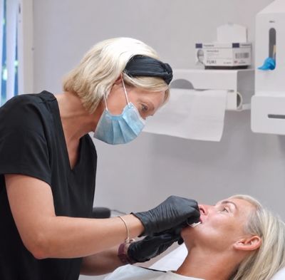 A dental professional examining a patient's teeth in a clinic.