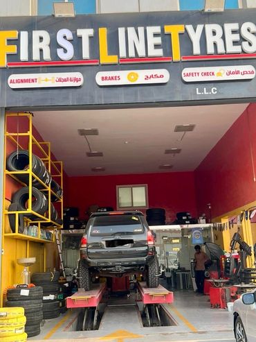 A car is lifted inside First Line Tyres garage for maintenance.