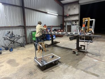 Person working in a metal workshop at night.