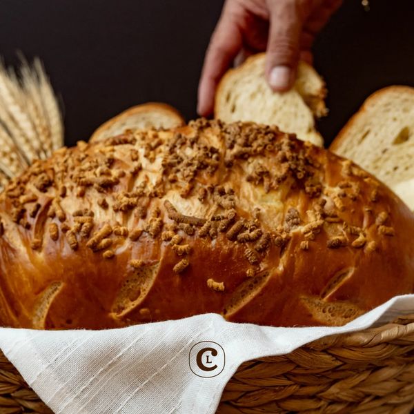Hand picking a slice of freshly baked bread from a basket.