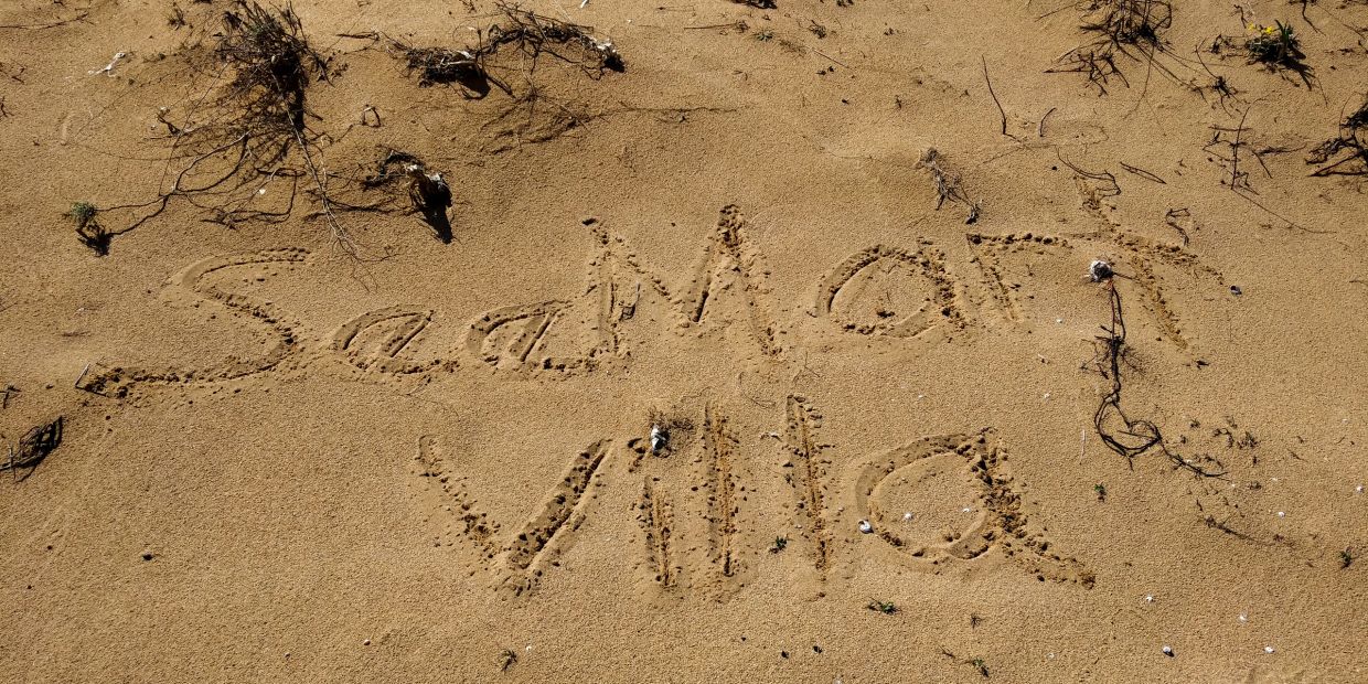 The words 'SaaMor Villa' written in sand on a beach.