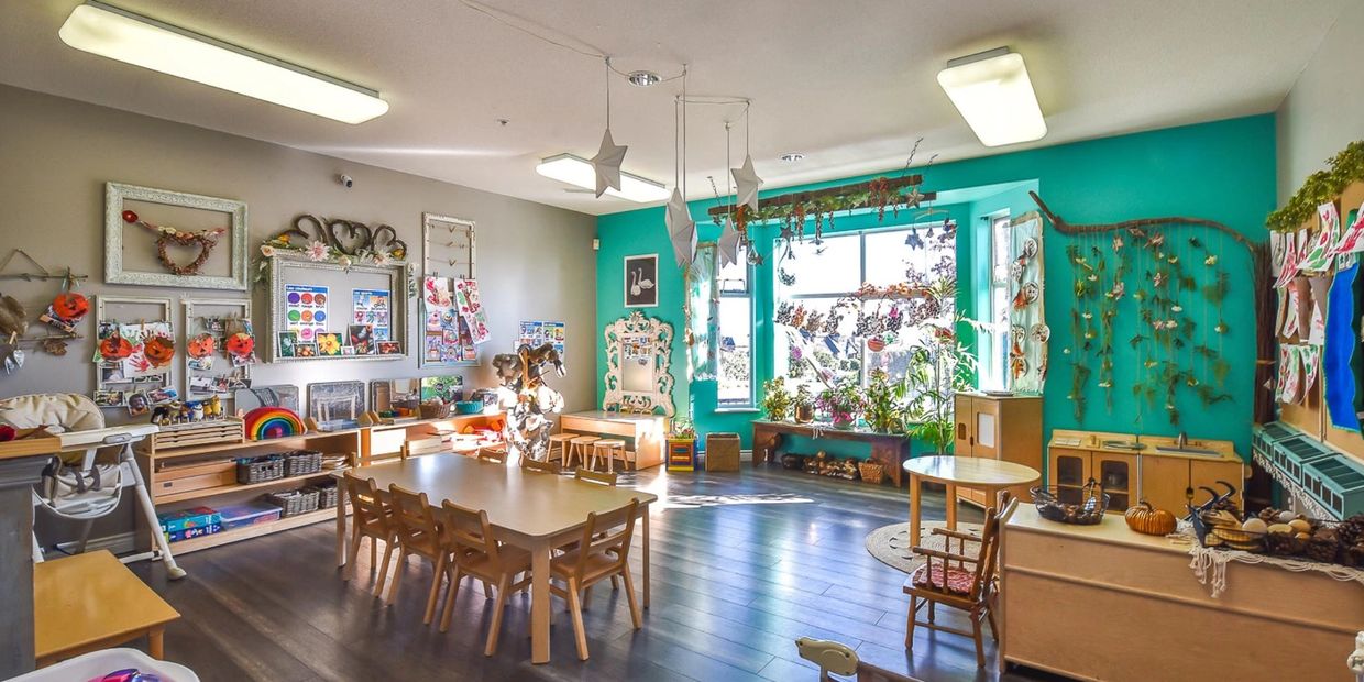 Bright, colorful classroom with wooden furniture and creative decorations.