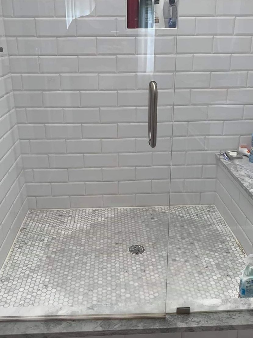 Carrara marble tile discoloration on shower floors