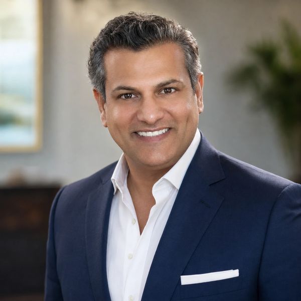 Confident man in navy blazer smiling.