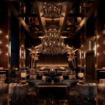 Luxurious lounge with opulent chandelier and animal print chairs.