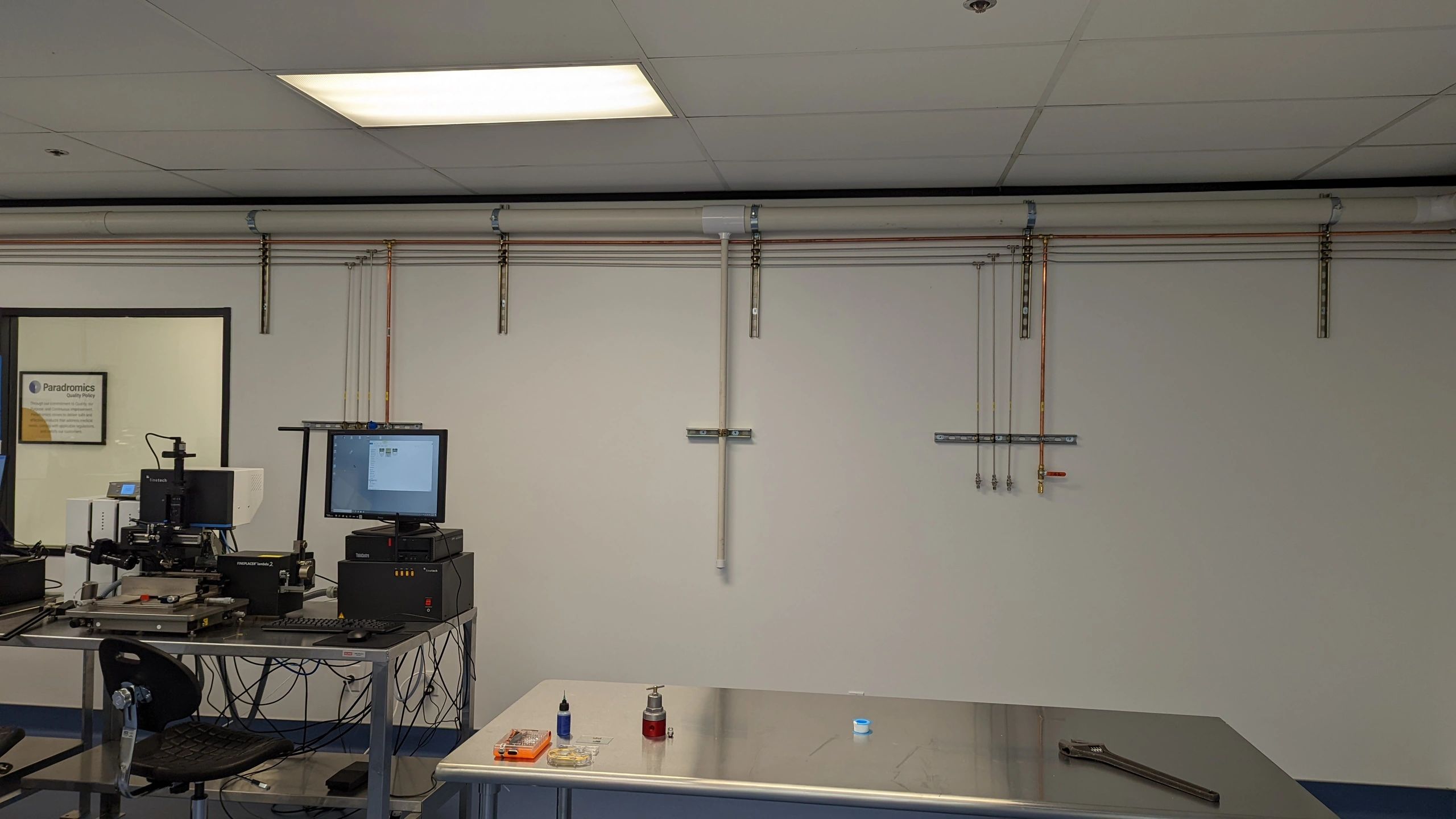 Laboratory setup with precision instruments and computer on a metal table.